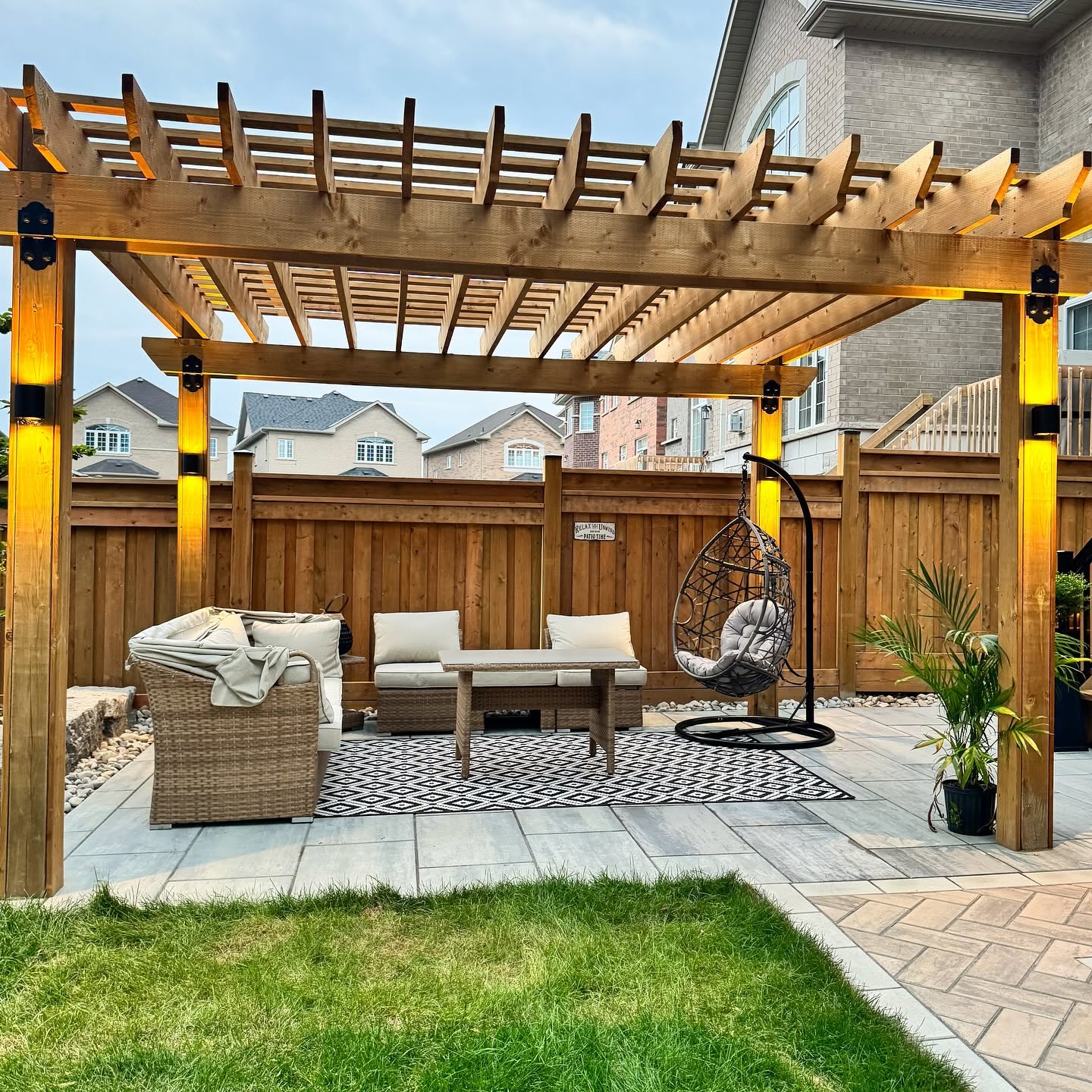 Custom cedar pergola with integrated post lighting over a paver patio